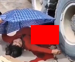 大型トラックのタイヤの下で臓器ぶちまけて横たわる女性